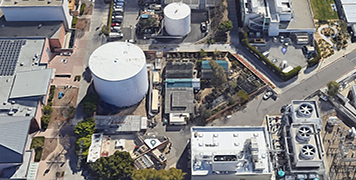 Aerial view of large industrial storage tanks and advanced mechanical systems illustrating central plant optimization