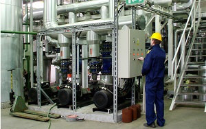 Technician operating mechanical equipment in a facility showcasing healthcare engineering services